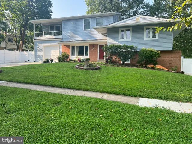 a front view of a house with a yard and green space
