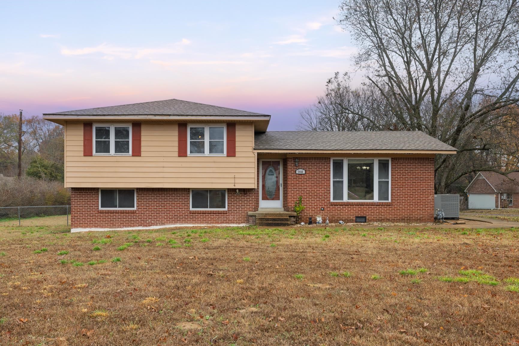 Split level home featuring brick siding, a shingled roof, and entry steps