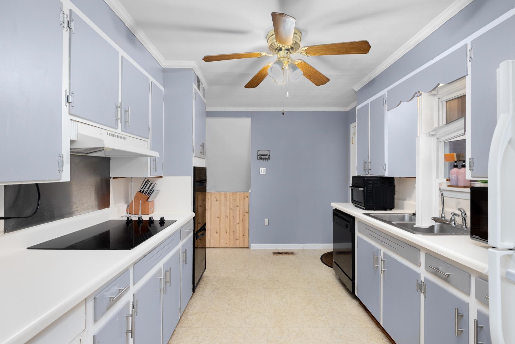 5466 Highway 59 Covington, TN 38019 - Photo 16 of 36 Kitchen with light countertops, ornamental molding, black appliances, light floors, and ceiling fan