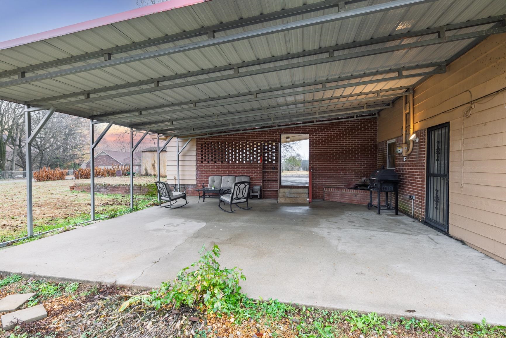 5466 Highway 59 Covington, TN 38019 - Photo 23 of 36 a view of a patio with table and chairs under an umbrella with a roof