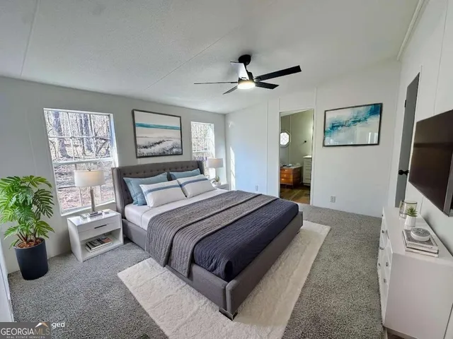 a bedroom with a large bed and a flat screen tv