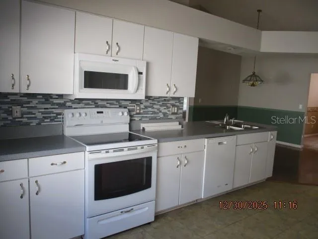 a kitchen with white cabinets stainless steel appliances and sink