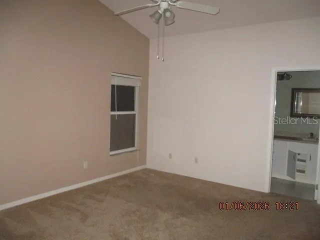 an empty room with a fireplace and a chandelier fan