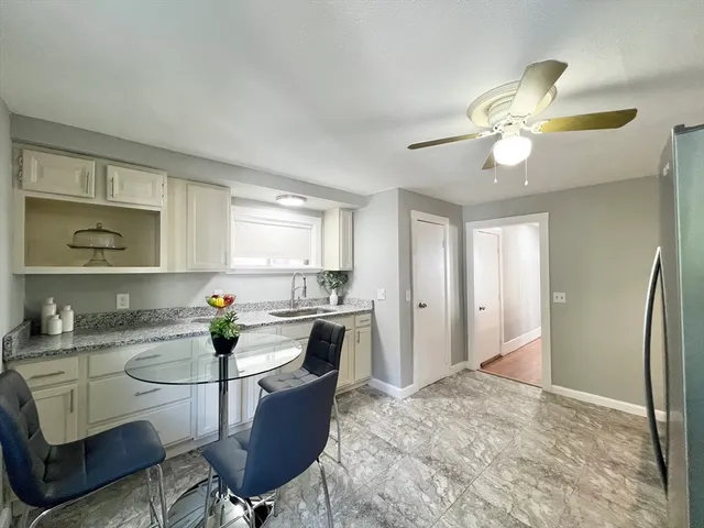 a kitchen with a dining table cabinets and stainless steel appliances