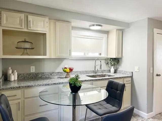 a kitchen with a white cabinets and chairs