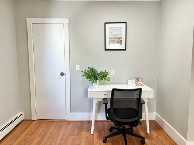 a view of a workspace with furniture and wooden floor