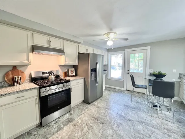 a kitchen with stainless steel appliances granite countertop a stove a refrigerator and a sink