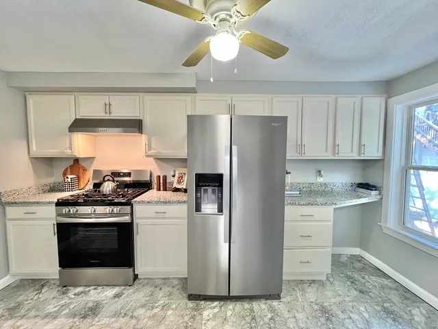 a kitchen with stainless steel appliances granite countertop a refrigerator a stove and a sink