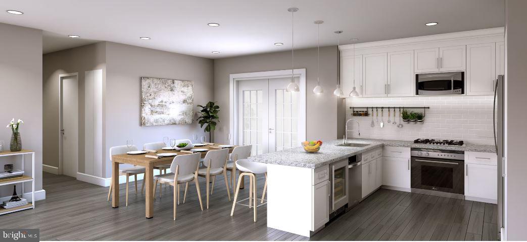a kitchen with stainless steel appliances granite countertop a stove a sink a microwave a island and chairs