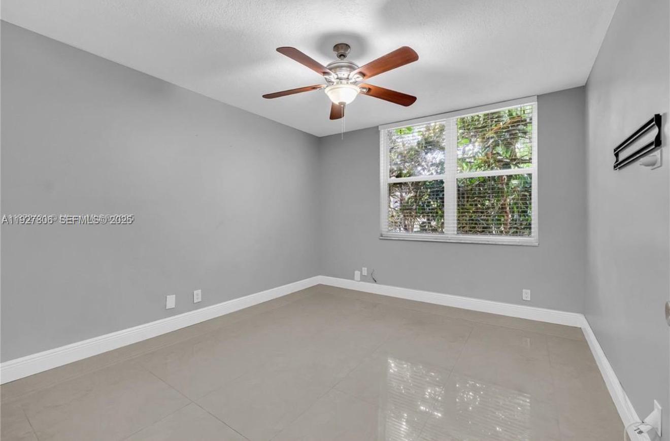9431 Live Oak Place, Unit 205 Davie, FL 33324 - Photo 5 of 13 an empty room with ceiling fan and window
