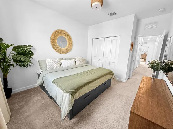 a bedroom with a bed and a potted plant