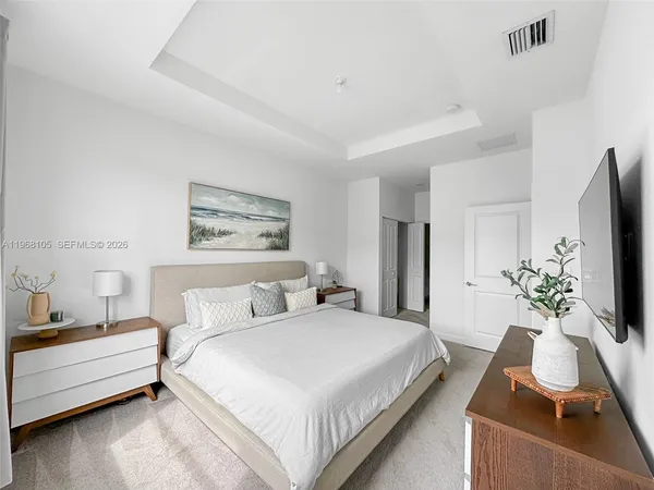 a bedroom with a bed and a flat screen tv