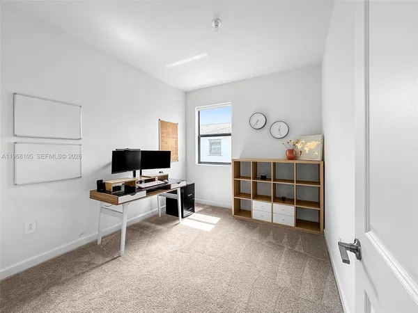 a view of a workspace with furniture and a window