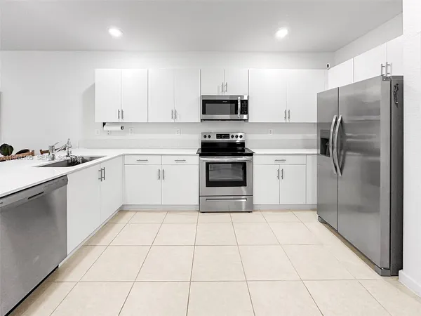 a kitchen with a stove a sink and a refrigerator