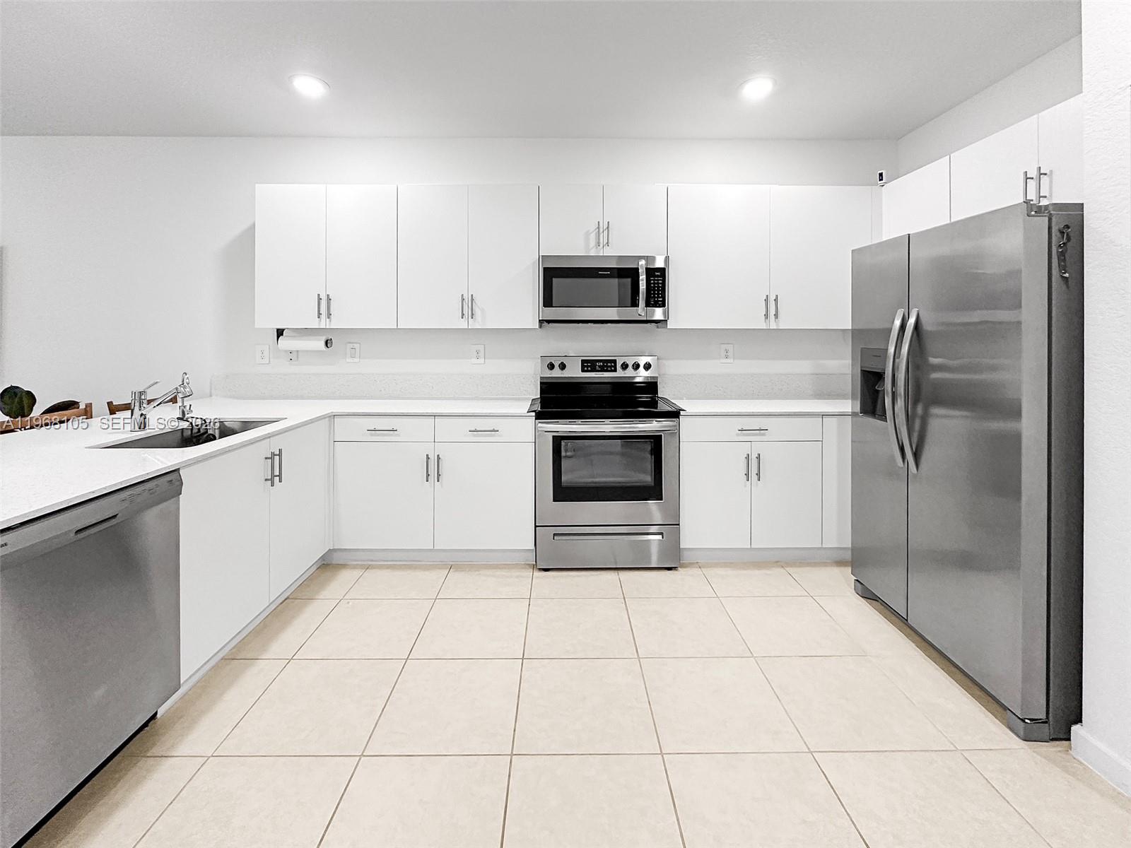 13402 Southwest 286th Street, Unit 13402 Homestead, FL 33033 - Photo 5 of 43 a kitchen with a stove a sink and a refrigerator