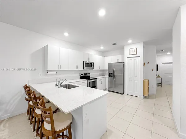 a kitchen with stainless steel appliances kitchen island granite countertop a refrigerator and a stove top oven