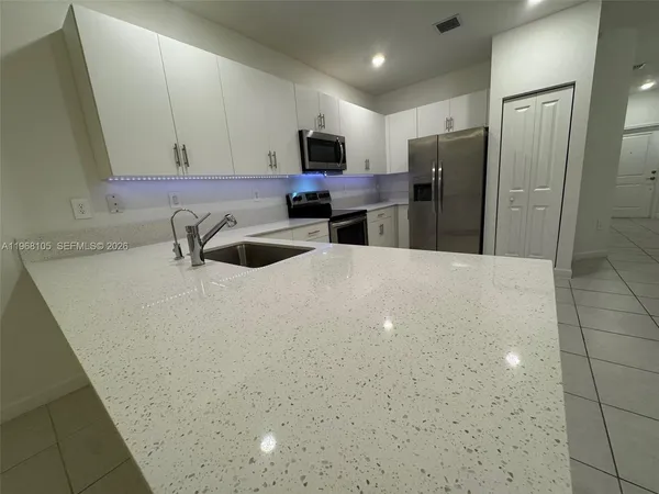 a kitchen with refrigerator and microwave