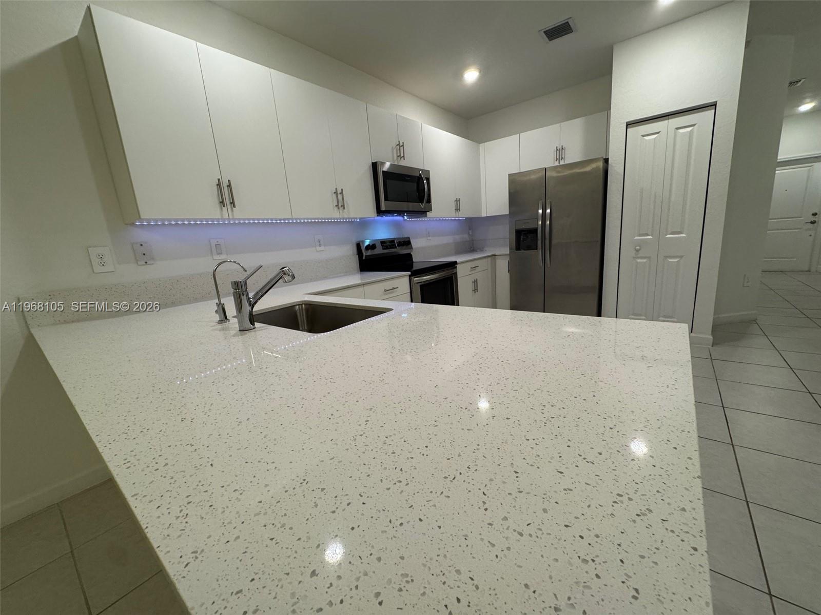 13402 Southwest 286th Street, Unit 13402 Homestead, FL 33033 - Photo 9 of 43 a kitchen with refrigerator and microwave