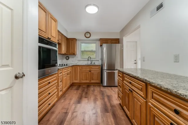 a kitchen with stainless steel appliances a refrigerator and a stove top oven