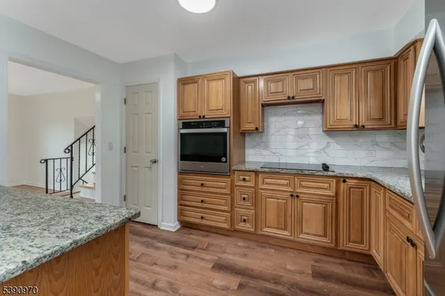 a kitchen with stainless steel appliances granite countertop a sink stove and cabinets