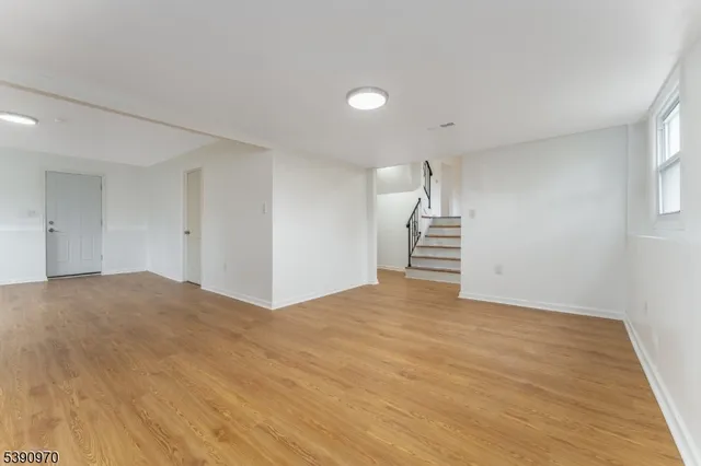 a view of empty room with wooden floor and window