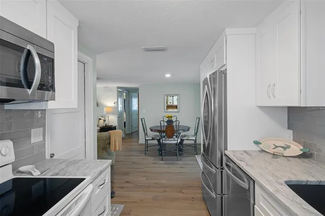 a kitchen with granite countertop a sink stove and cabinets