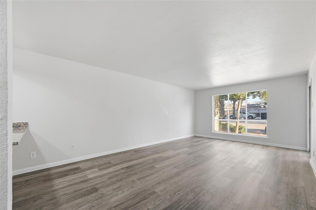 4851 Cedar Springs Road, Unit 189 Dallas, TX 75219 - Photo 11 of 29 an empty room with wooden floor and window