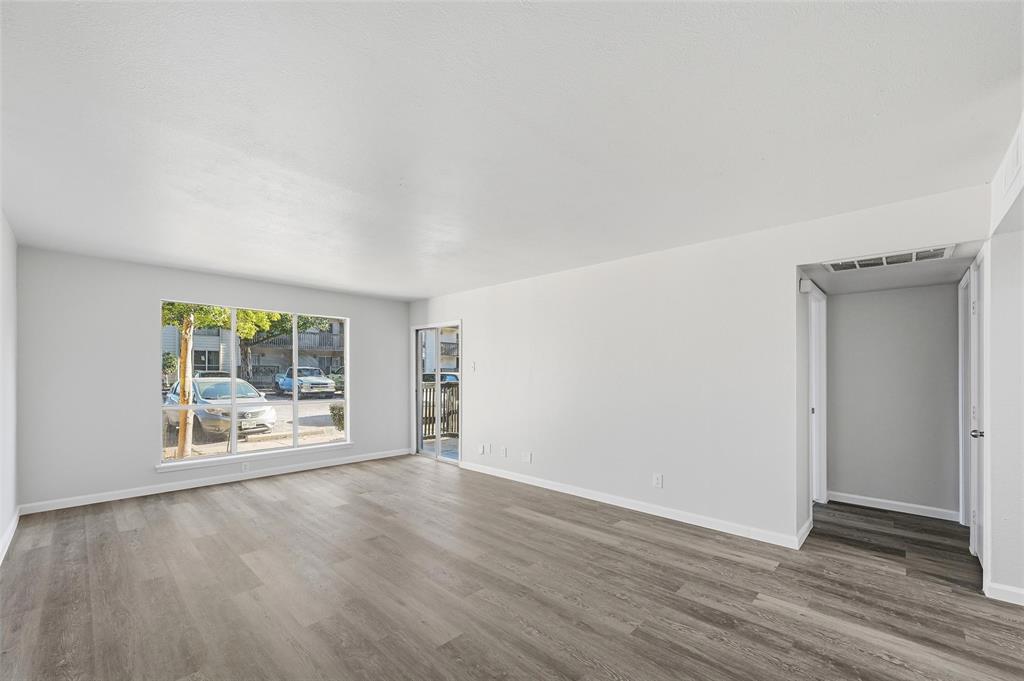 4851 Cedar Springs Road, Unit 189 Dallas, TX 75219 - Photo 12 of 29 an empty room with wooden floor and windows