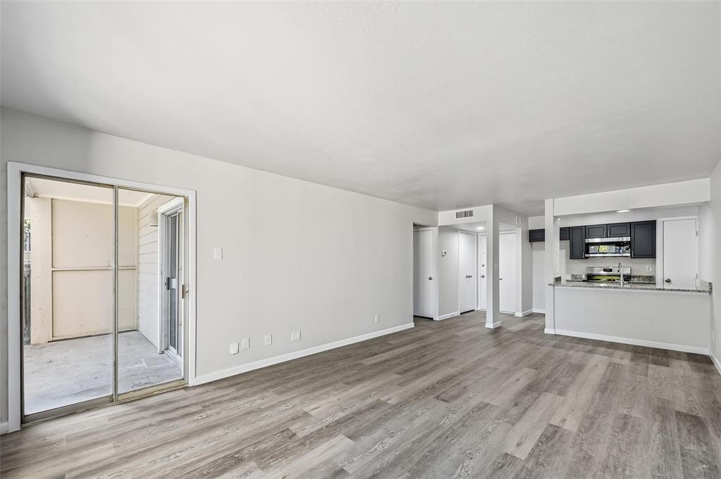 4851 Cedar Springs Road, Unit 189 Dallas, TX 75219 - Photo 4 of 29 an empty room with wooden floor and window