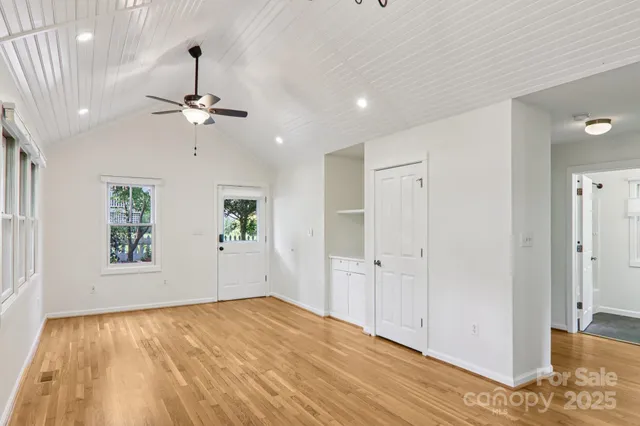 a view of a livingroom with a chandelier fan and wooden floor