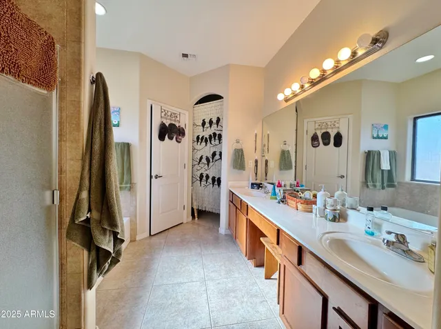 a bathroom with a double vanity sink a mirror and a shower