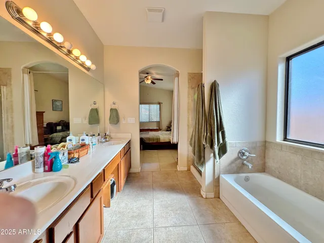 a bathroom with a tub sink and mirror