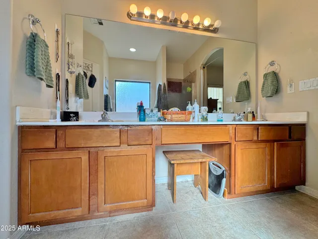 a room with cabinets a sink and a mirror