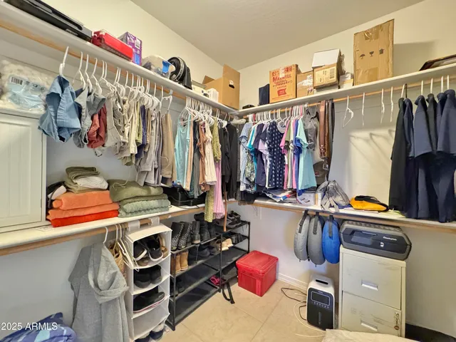 a view of walk in closet with clothes and shoes