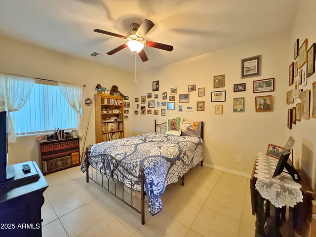 a bed room with a bed and a ceiling fan
