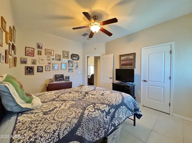 a bedroom with a large bed and a ceiling fan