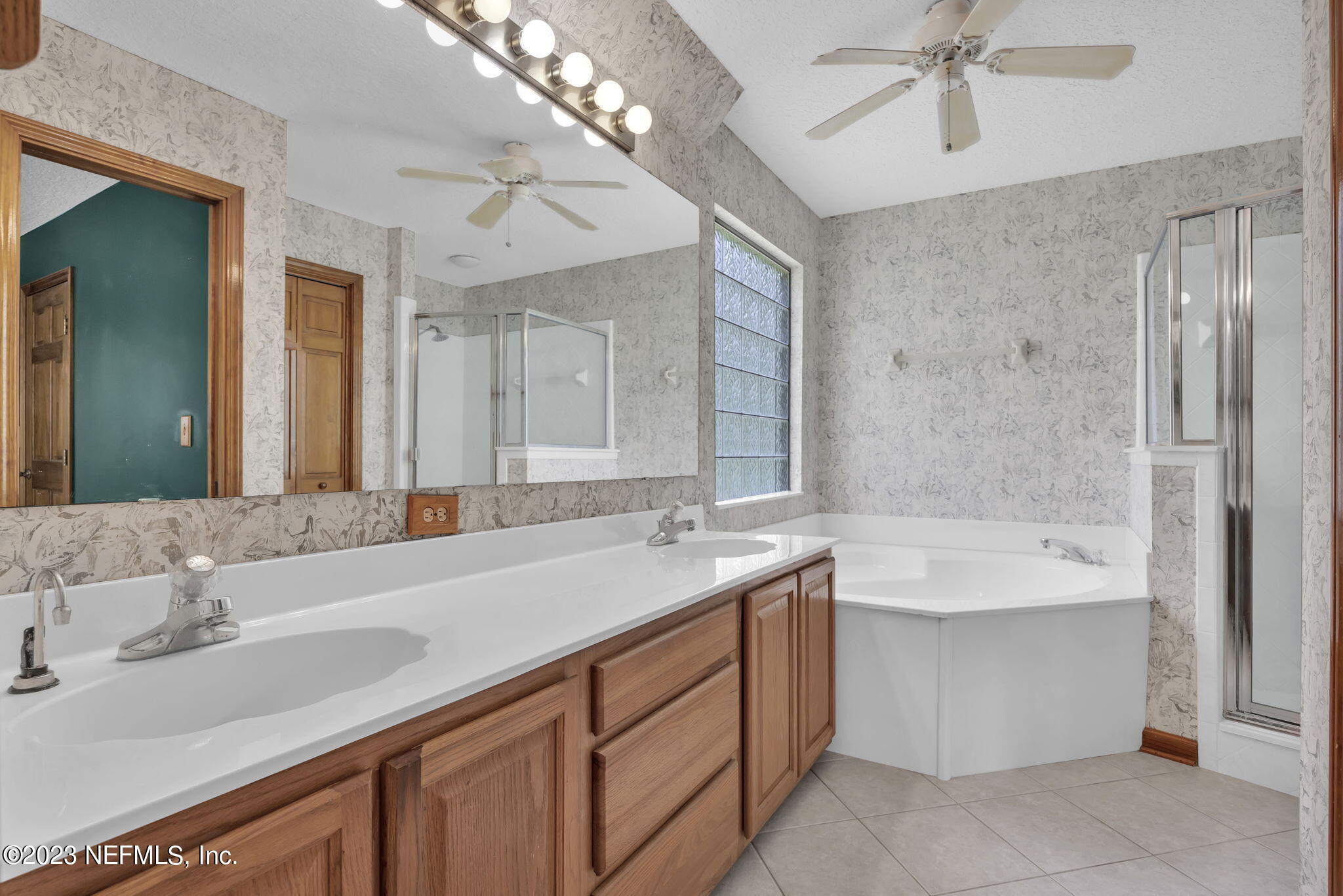 1387 Lee Road St. Johns, FL 32259 - Photo 32 of 62 a bathroom with a sink double vanity granite tub shower and a mirror