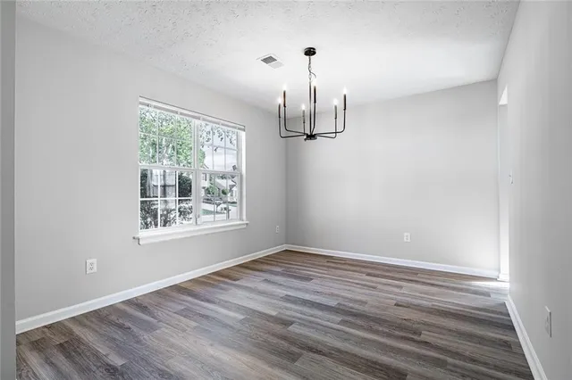 a view of empty room with wooden floor and window