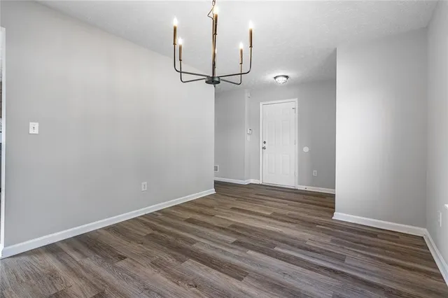a view of empty room with wooden floor and ceiling fan