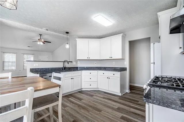 a kitchen with white cabinets and appliances