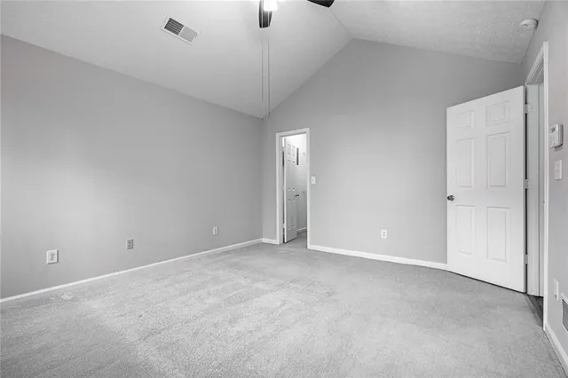 an empty room with ceiling fan and windows