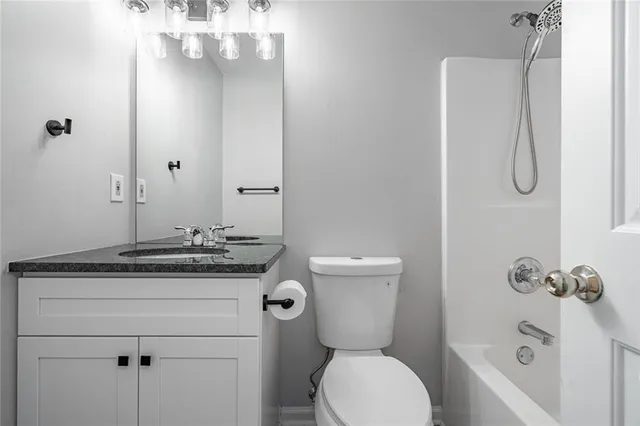 a bathroom with a granite countertop sink toilet and shower