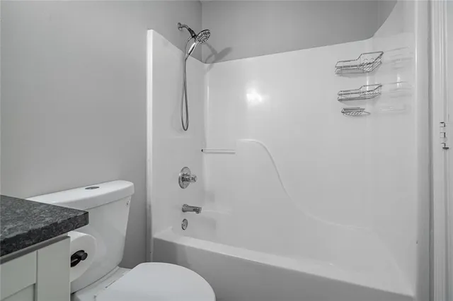 a bathroom with a granite countertop toilet sink and shower