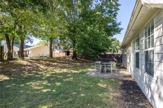 a backyard of a house with table and chairs