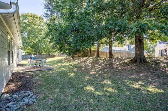 a backyard of a house with table and chairs