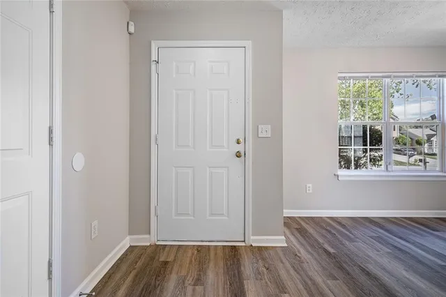 a view of a room with wooden floor and window