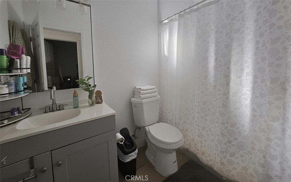 6836 Colmar Avenue, Unit 1/4 Bell Gardens, CA 90201 - Photo 3 of 6 a bathroom with a toilet sink and mirror