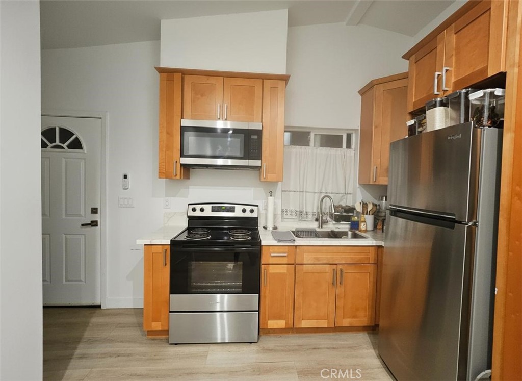 6836 Colmar Avenue, Unit 1/4 Bell Gardens, CA 90201 - Photo 5 of 6 a kitchen with a refrigerator stove and microwave