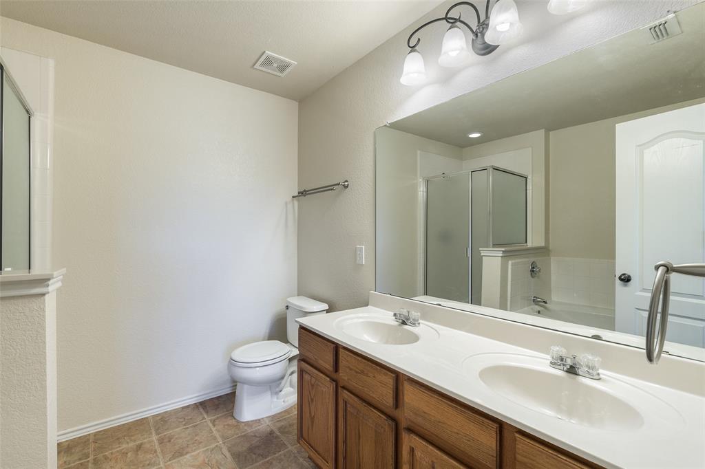 3917 Mantis Street Fort Worth, TX 76106 - Photo 12 of 22 a bathroom with a granite countertop sink a toilet and a mirror