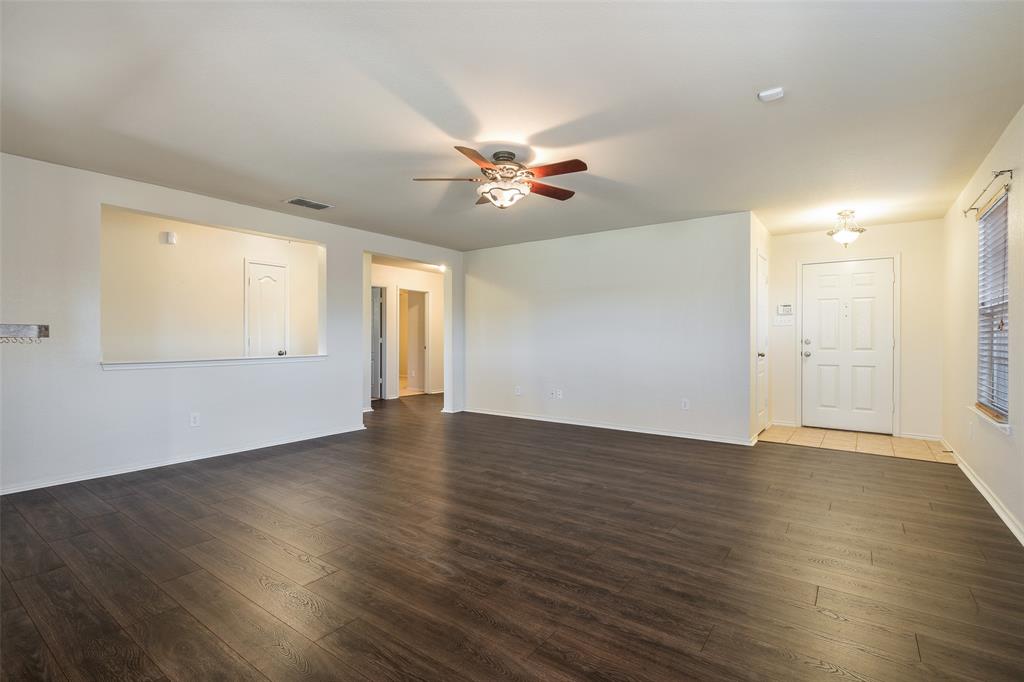 3917 Mantis Street Fort Worth, TX 76106 - Photo 8 of 22 a view of an empty room with wooden floor and a ceiling fan